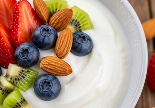 Yaourt nature avec quelques amandes et fruits frais